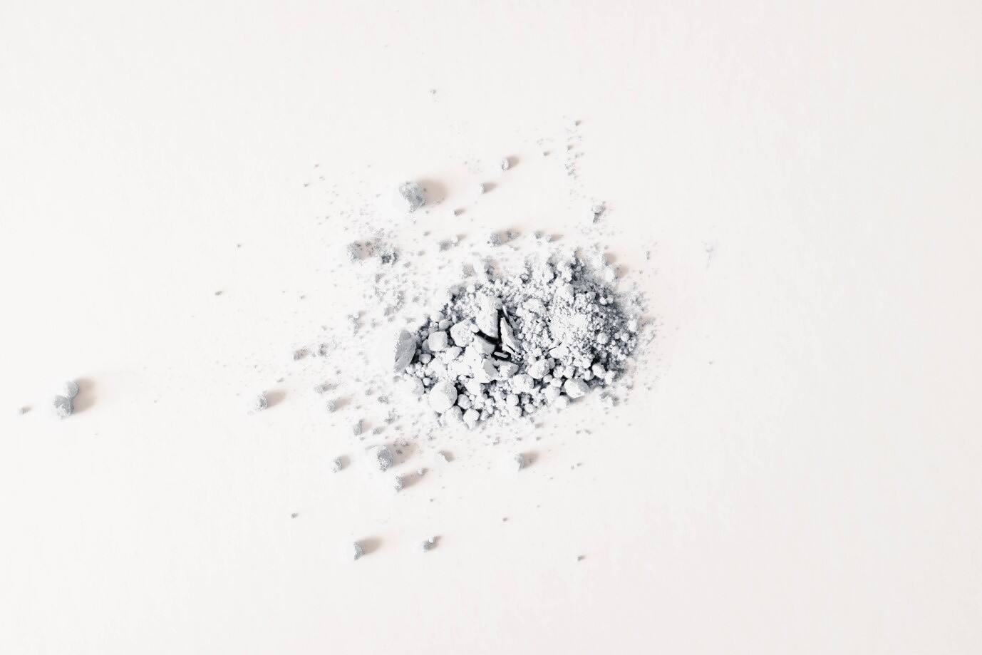 Close-up of a small pile of white cocaine powder scattered on a plain surface, illustrating the dangers of drug abuse and the need for addiction treatment