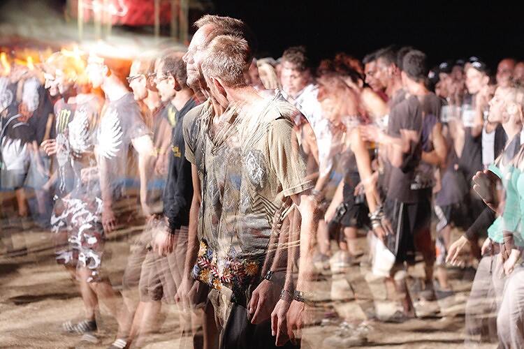 Crowd of young people at a music festival, with blurred motion suggesting drug influence and potential substance abuse among students