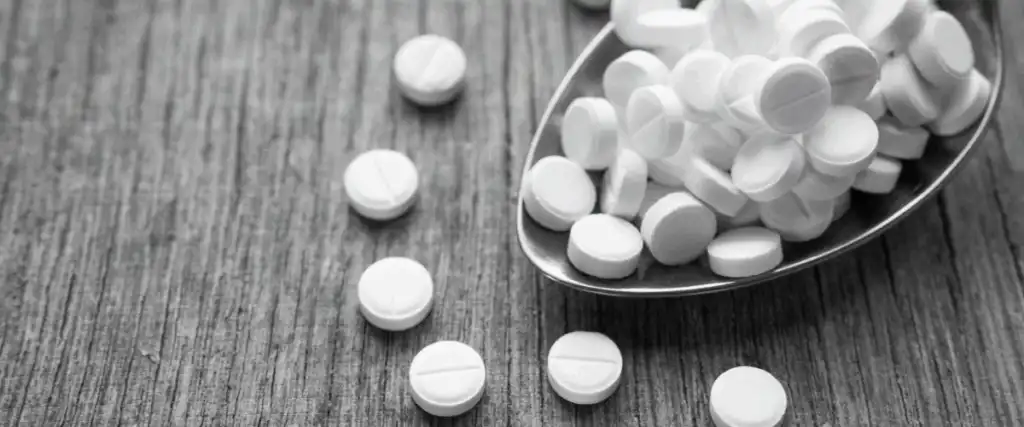 Opioid pills on a spoon and table