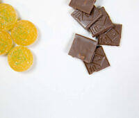 Comparison of cannabis edibles: yellow gummies with sugar crystals and dark chocolate squares marked '10mg'