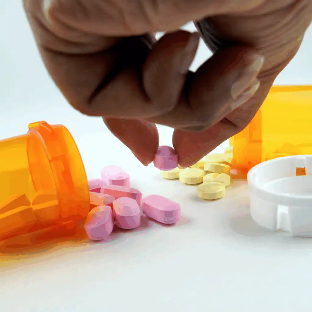 Drug Detection Timeframes: Understanding How Long Various Substances Remain in Your System Hand reaching towards various drugs including pills and vials on a white background, illustrating the diverse substances detectable in the body