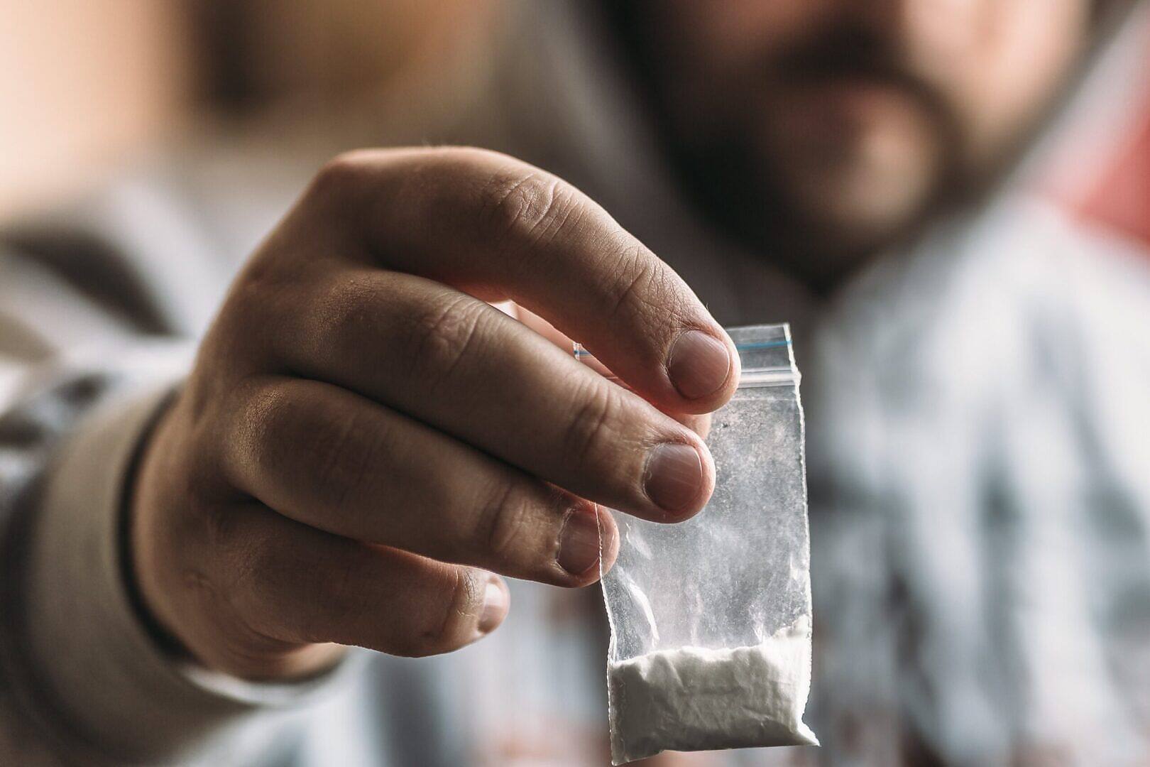 Close-up of white powdery substance resembling cocaine arranged in lines on a reflective surface, illustrating the dangers of cocaine use