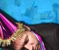 Man passed out at Christmas office party wearing purple party hat and tinsel, illustrating risks of holiday alcohol overconsumption