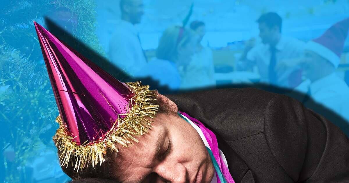 Man passed out at Christmas office party wearing purple party hat and tinsel, illustrating risks of holiday alcohol overconsumption