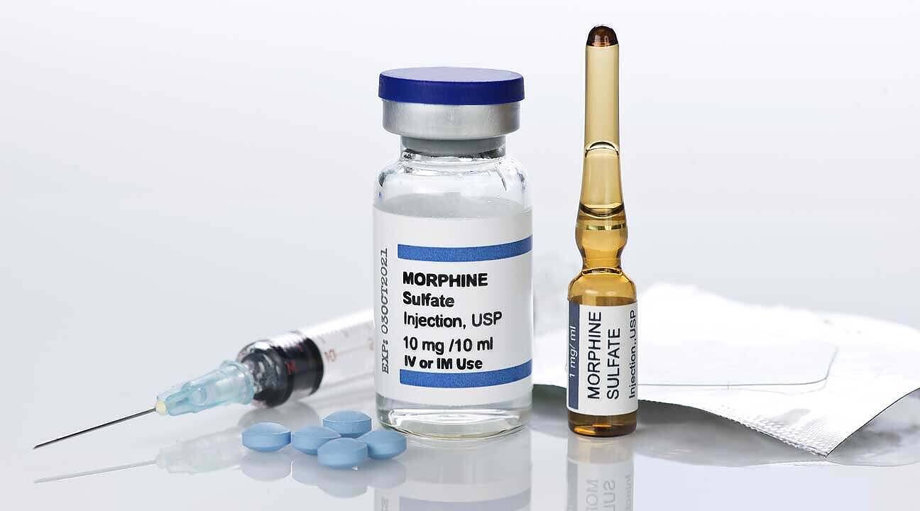 Morphine sulfate injection vial, ampoule, syringe, and pills used for pain management but with addiction potential