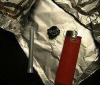 Tools for smoking black tar heroin including a foil, lighter, and straw