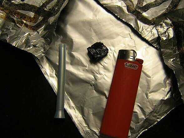 Tools for smoking black tar heroin including a foil, lighter, and straw