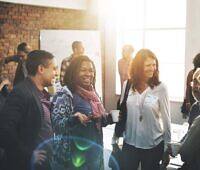 Diverse group of people smiling and interacting during a support meeting at an alcohol rehab center in Leicestershire