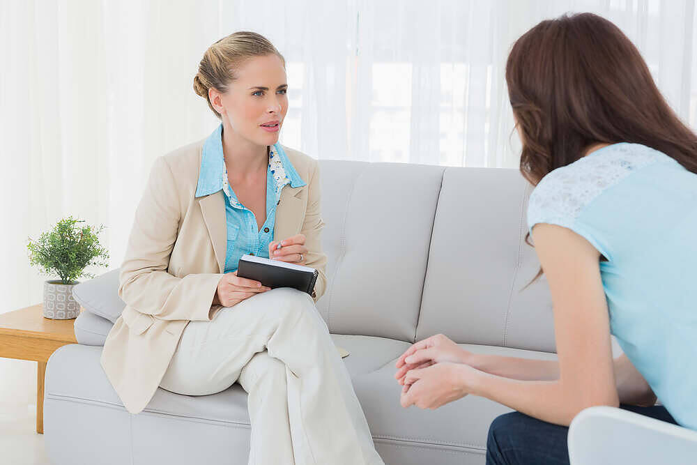 Compassionate therapist listening attentively to patient during a counseling session at a Manchester rehabilitation facility