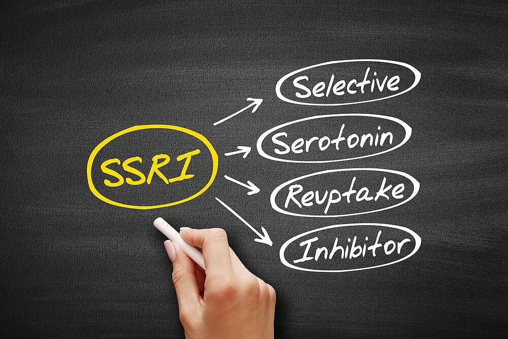 Diagram explaining SSRI (Selective Serotonin Reuptake Inhibitors) on a chalkboard, showing its components: Selective, Serotonin, Reuptake, and Inhibitor