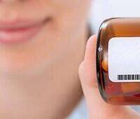 Close-up of a healthcare worker's hand holding a prescription bottle labeled Prednisone