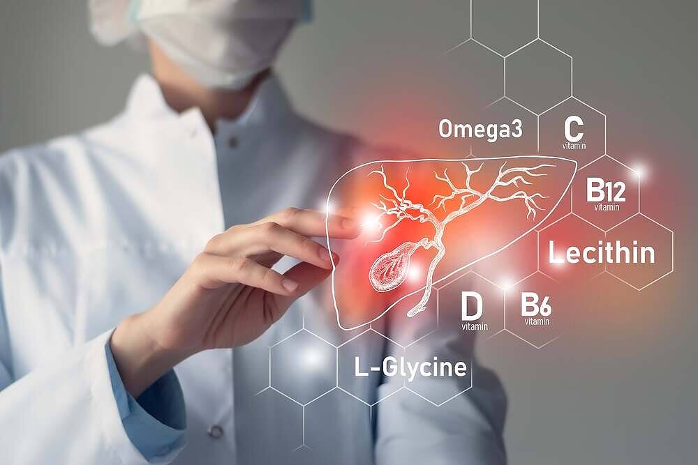 Medical professional pointing at digital illustration of liver with labeled vitamins and nutrients including Omega3, Vitamin C, B12, D, B6, Lecithin, and L-Glycine for liver repair