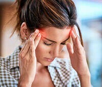 Young woman holding her head in pain, experiencing brain zaps as a withdrawal symptom during drug or alcohol detox