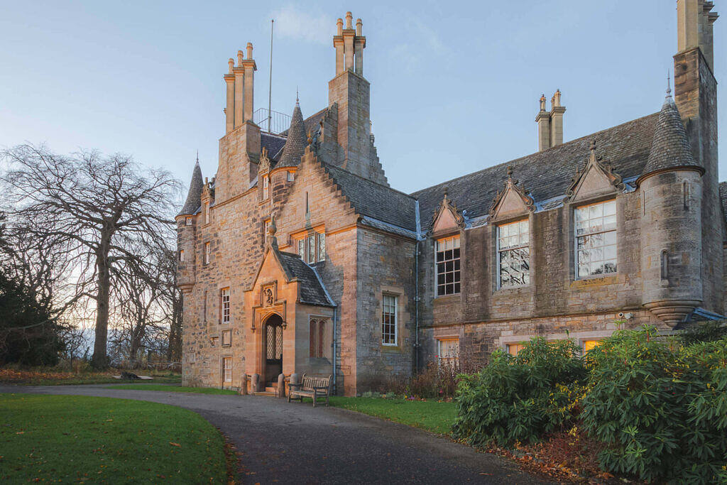 Historic Scottish manor house with stone facade and turrets, serving as a luxurious rehab facility in Glasgow