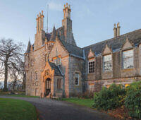 Historic Scottish manor house with stone facade and turrets, serving as a luxurious rehab facility in Glasgow