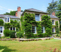 Charming English country house with ivy-covered walls, surrounded by lush gardens, ideal for alcohol rehabilitation in England