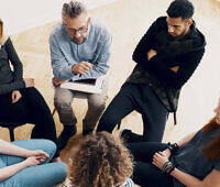 Diverse group of individuals participating in a therapy session for alcohol addiction recovery in Kent