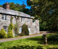 Picturesque stone cottage rehab center in rural Wales surrounded by lush greenery and trees