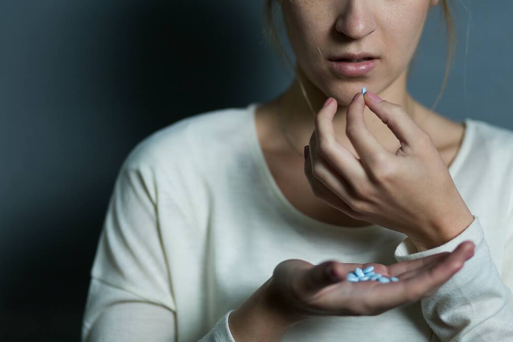 Depressed girl taking a lot of drugs