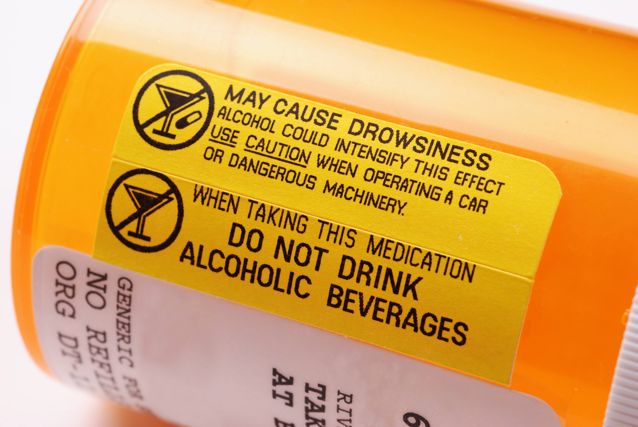 Close-up of a prescription bottle label warning against mixing alcohol with medication, highlighting drowsiness and safety risks