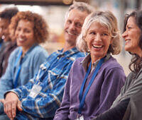 Smiling participants in a group therapy session at an alcohol rehab facility in Birmingham, showing diversity and positive engagement