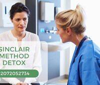 Patient discussing Sinclair Method detox with healthcare provider in clinical setting, phone number displayed