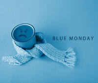 Blue mug with sad face wrapped in light blue scarf, representing Blue Monday and seasonal depression