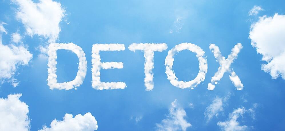 The word 'DETOX' spelled out in cloud letters against a bright blue sky, symbolizing hope and clarity in drug recovery