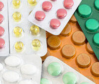 Assorted prescription pill blister packs in different colors including red, yellow, green, orange, and white tablets