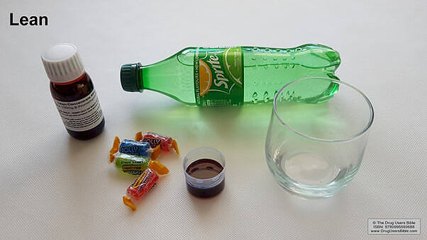 Components of Lean drug mixture: bottle of codeine cough syrup, Sprite soda, candy, and a glass for mixing