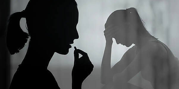 Silhouette of two women, one holding her head in distress, representing the mental health struggles of ketamine addiction