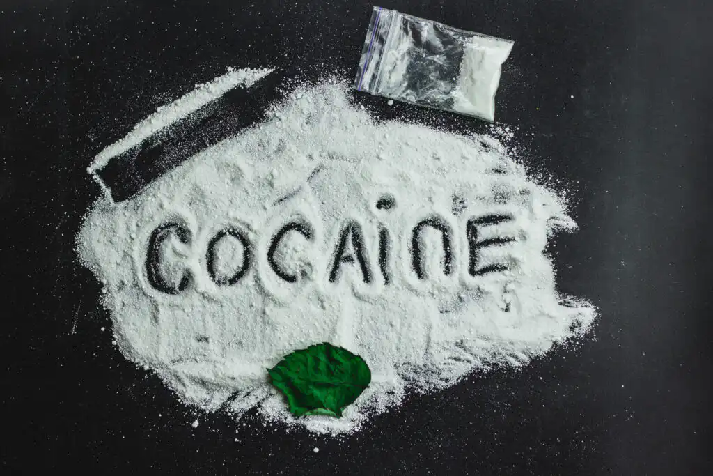 cocaine powder spread across a black table with the word cocaine written in it