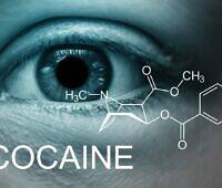 Close-up of a human eye with dilated pupil, overlaid with the chemical structure of cocaine and the word 'COCAINE' in bold text, illustrating cocaine addiction impact on the body