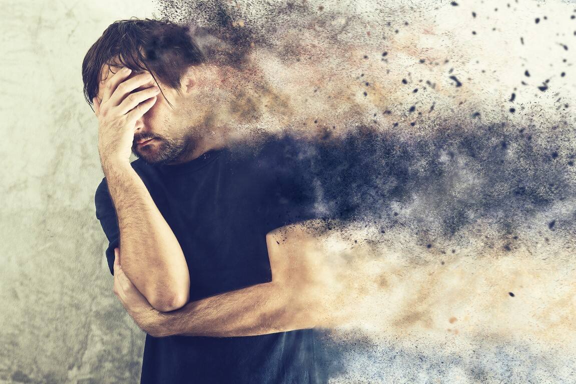 Man covering face with hand as his body appears to disintegrate, illustrating the devastating physical and psychological effects of cocaine addiction