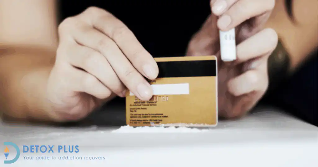 woman with an addiction using a credit card to take cocaine