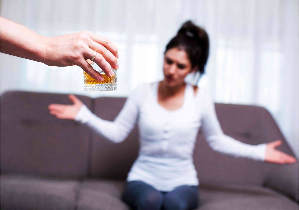 A woman refusing a glass of alcohol, symbolizing the journey to sobriety and recovery.