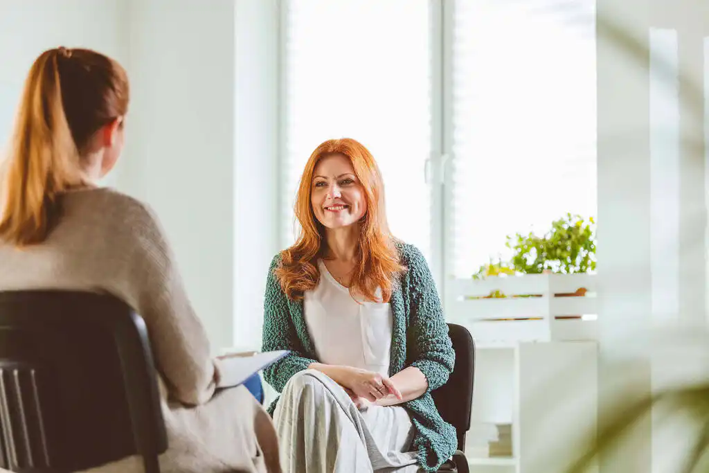 a woman sitting in a chair and smiling