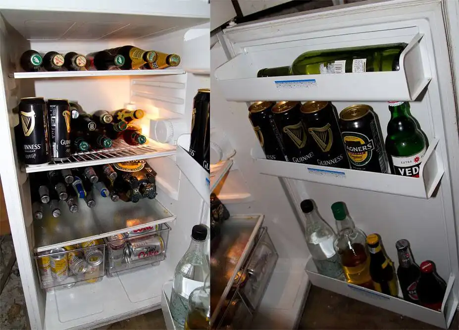 Refrigerator filled with various alcoholic beverages including beer, wine, and spirits, indicating excessive alcohol consumption|