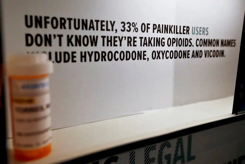 Warning sign stating 33% of painkiller takers users don't know they're taking opioids, listing common names like hydrocodine, oxycodone and vicodin