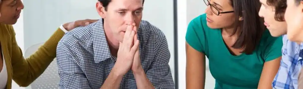 A support group session with individuals discussing teen drug addiction, showing empathy and concern.