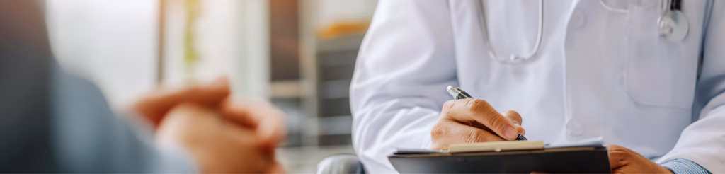doctor meeting with an alcohol detox patient writing prescription with a pen